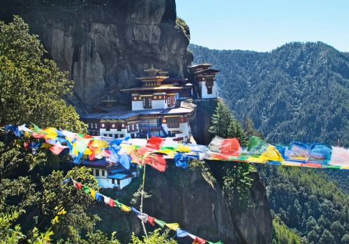 Prayer flags in front of a cliff-side monastery in Bhutan